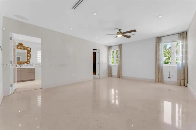 an empty room with windows and ceiling fan