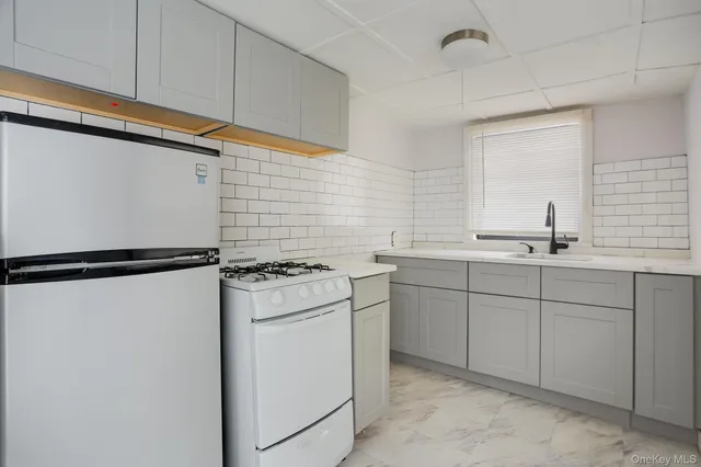 a kitchen with white cabinets and white appliances