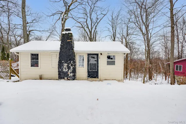 a view of a white house with a large tree