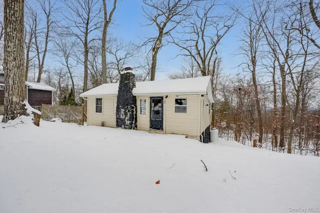 a front view of a house with a yard covered in snow