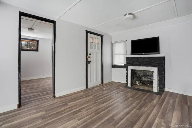 a view of a livingroom with a fireplace and wooden floor