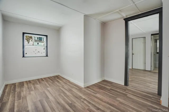 a view of an empty room with wooden floor