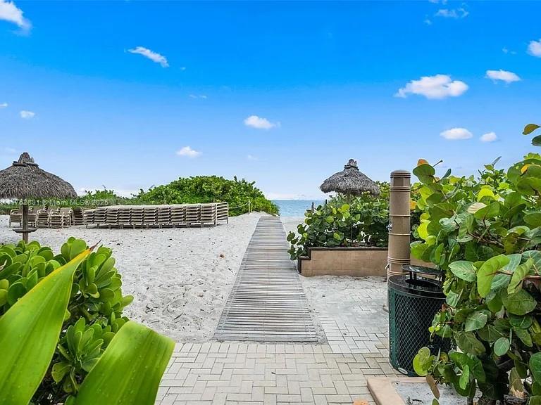 1121 Crandon Boulevard, Unit E203 Key Biscayne, FL 33149 - Photo 16 of 22 a view of a garden with plants and a bench