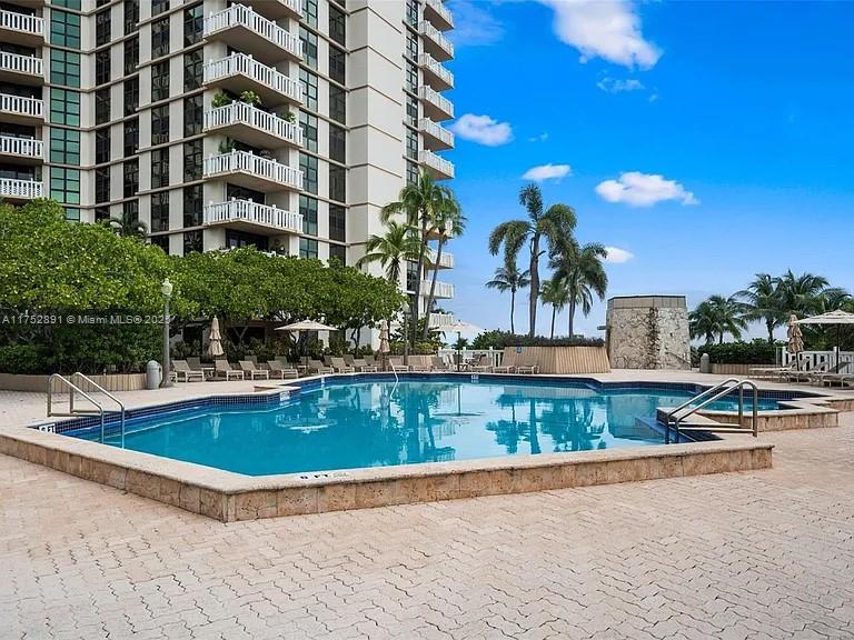 1121 Crandon Boulevard, Unit E203 Key Biscayne, FL 33149 - Photo 20 of 22 a view of a swimming pool with a lounge chairs