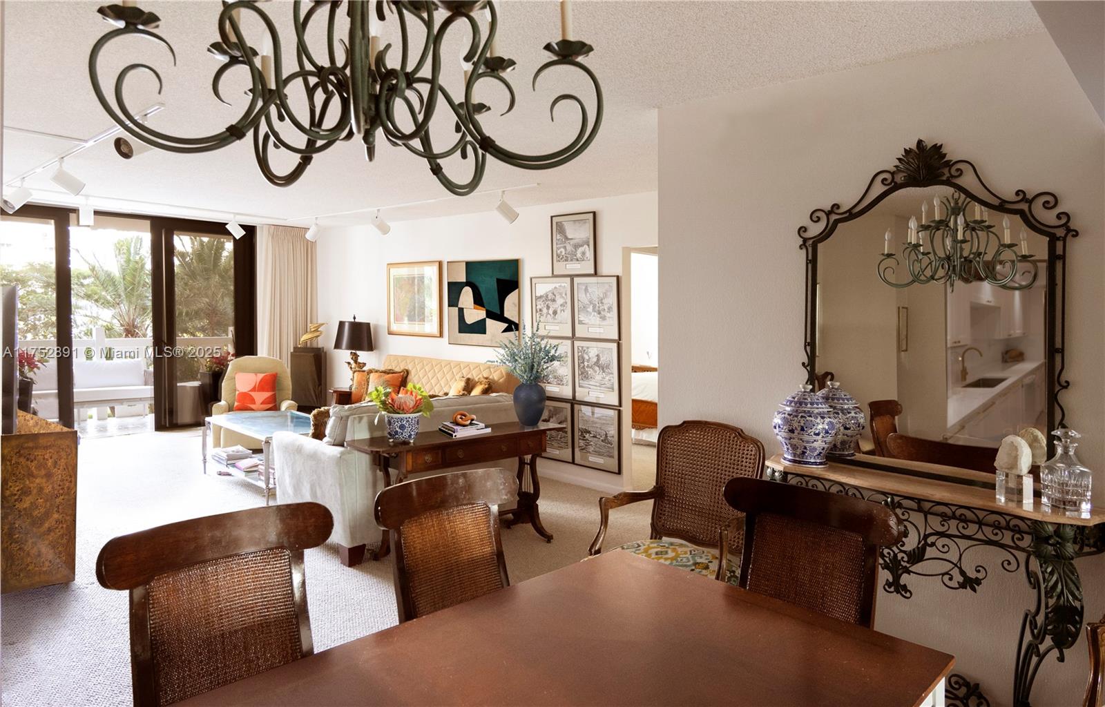 1121 Crandon Boulevard, Unit E203 Key Biscayne, FL 33149 - Photo 4 of 22 a living room with furniture a chandelier a fireplace and a large mirror