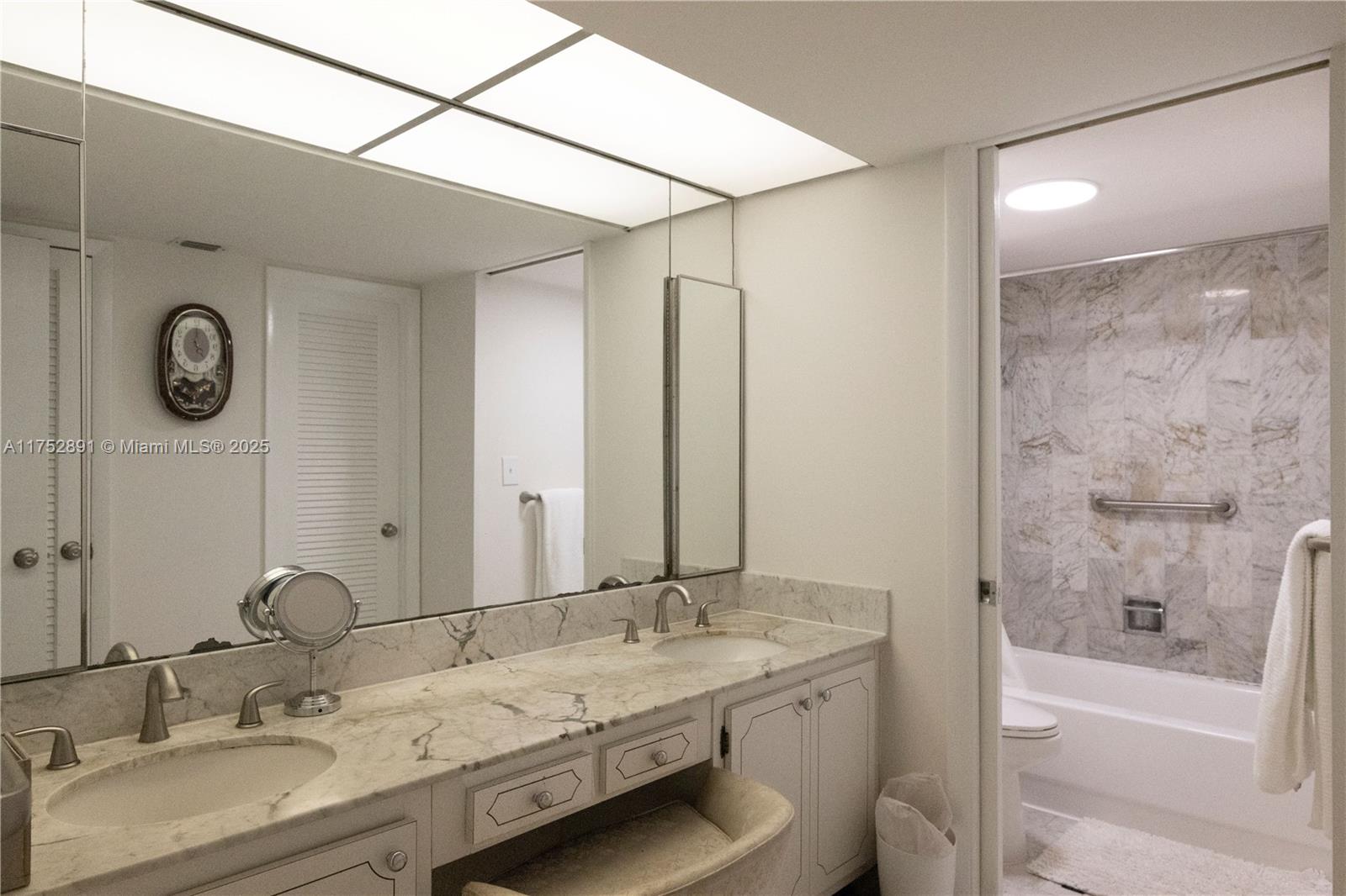 1121 Crandon Boulevard, Unit E203 Key Biscayne, FL 33149 - Photo 9 of 22 a bathroom with a granite countertop sink mirror and a bathtub