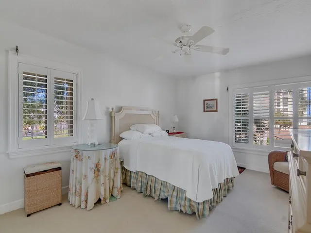a bedroom with a bed a window and a flat screen television