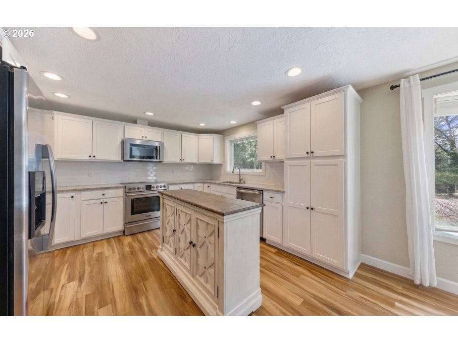 7624 Shady Way Southeast Turner, OR 97392 - Photo 12 of 48 a kitchen with stainless steel appliances granite countertop a refrigerator a sink dishwasher and a stove with wooden floor