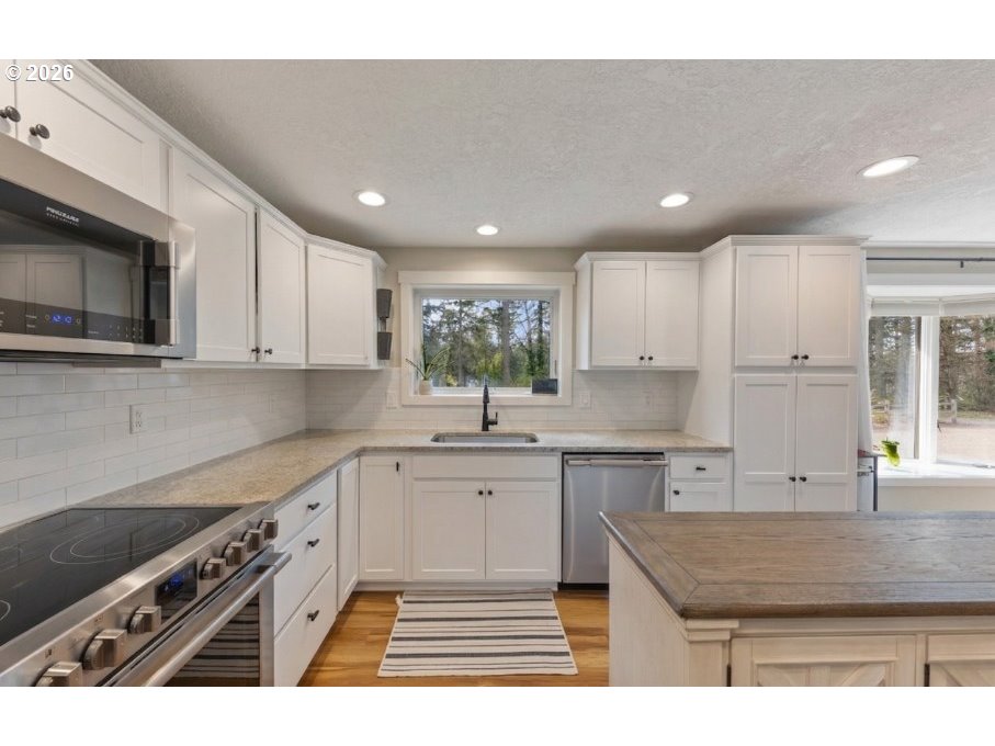 7624 Shady Way Southeast Turner, OR 97392 - Photo 13 of 48 a kitchen with stainless steel appliances granite countertop a stove a sink dishwasher and a microwave oven with white cabinets