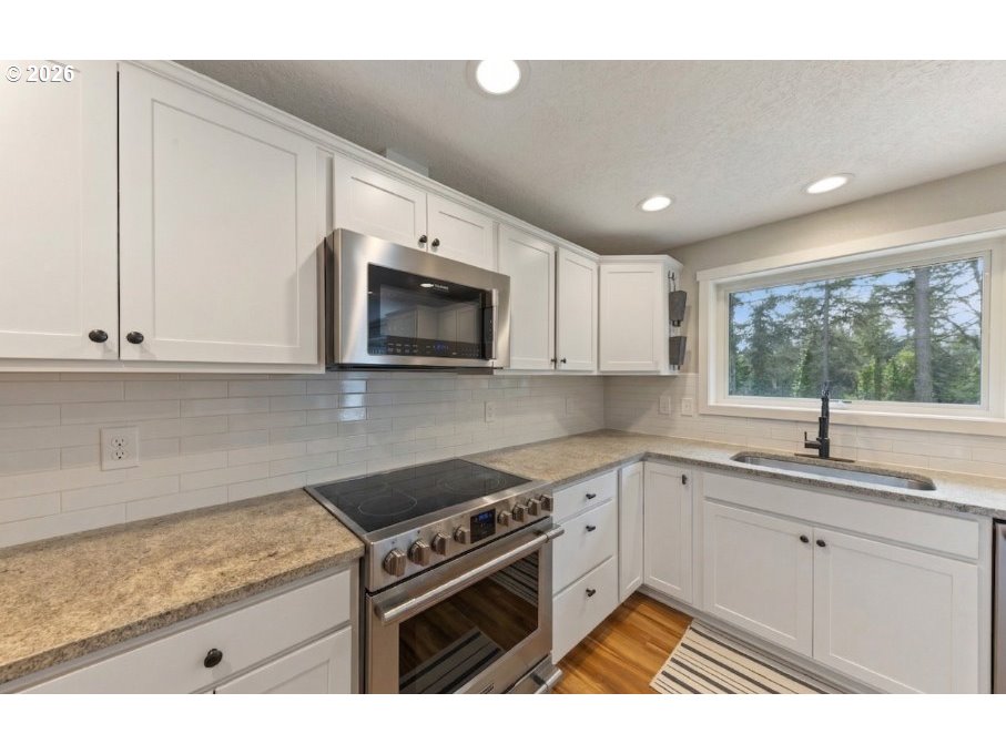 7624 Shady Way Southeast Turner, OR 97392 - Photo 14 of 48 a kitchen with stainless steel appliances granite countertop a sink a stove a microwave a refrigerator a window and cabinets