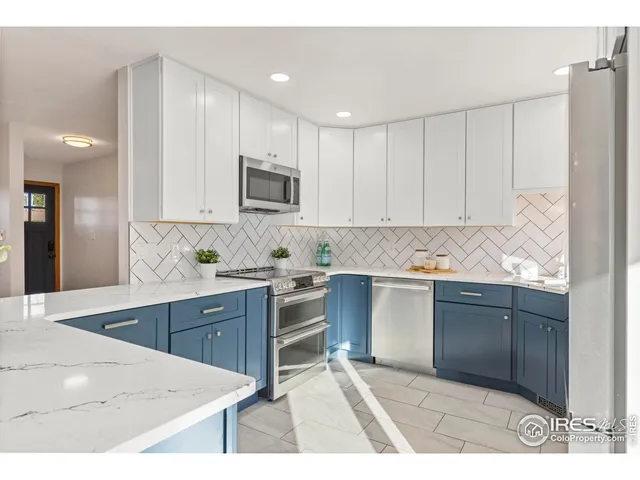 a kitchen with kitchen island white cabinets appliances and a sink