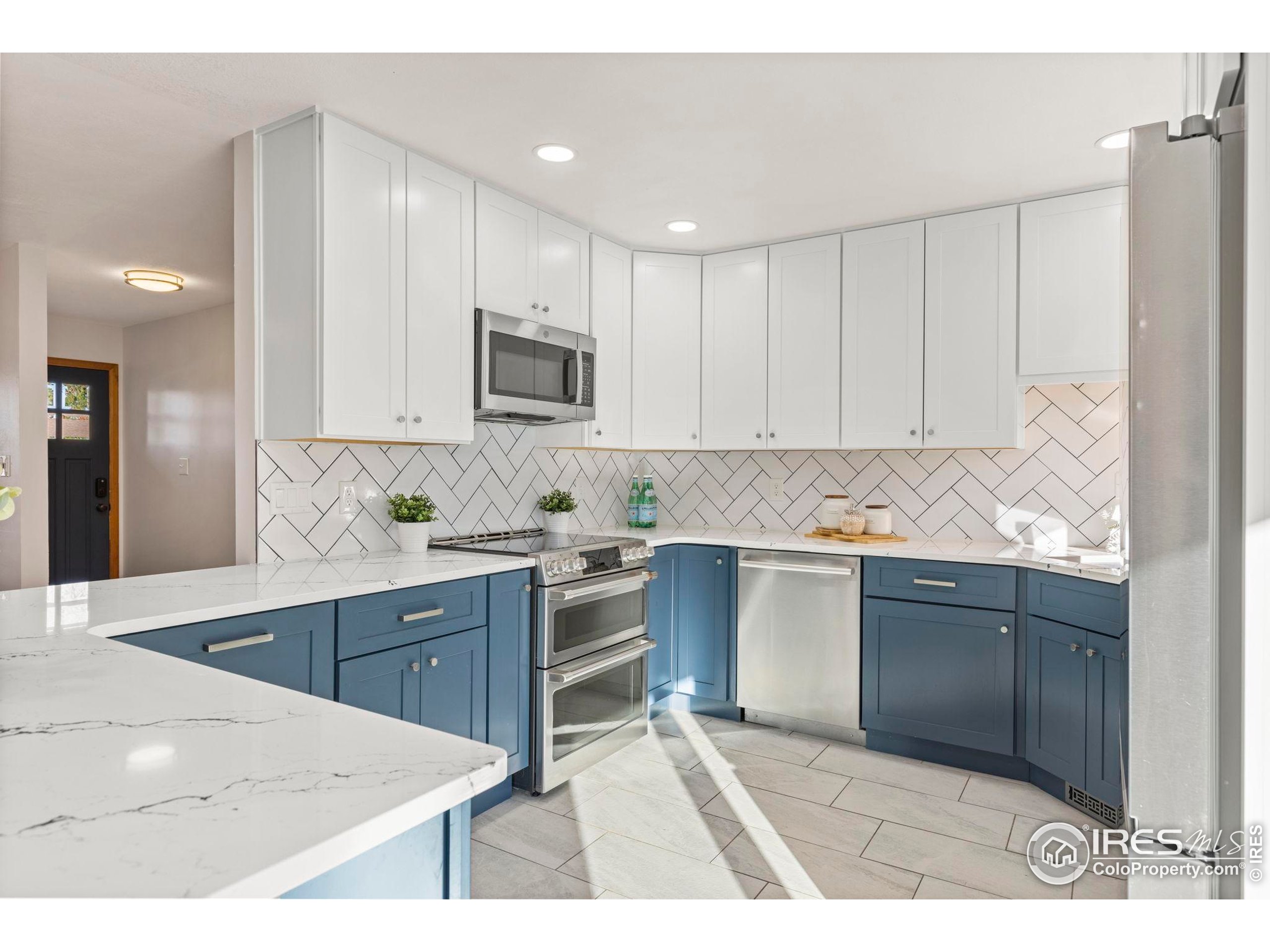 a kitchen with kitchen island white cabinets appliances and a sink