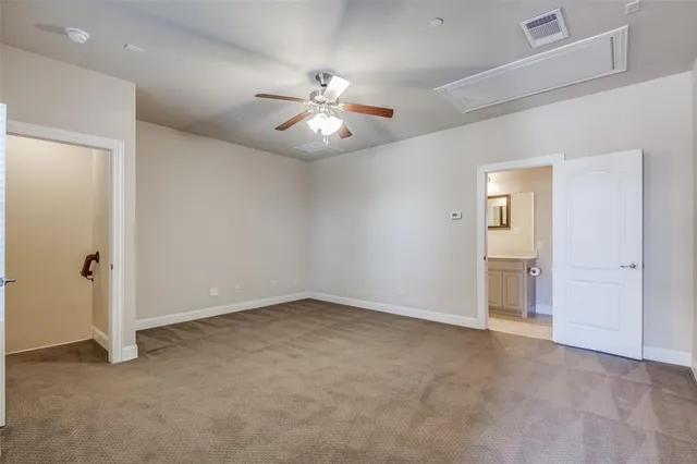 an empty room with closet and a chandelier fan