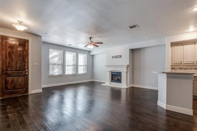 a view of an empty room with window and wooden floor