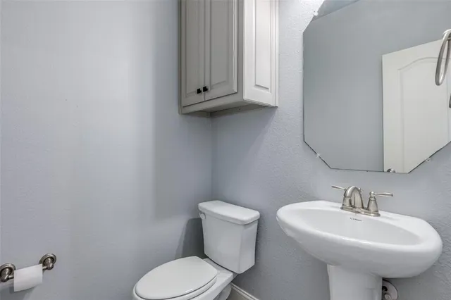 a bathroom with a sink a toilet and mirror