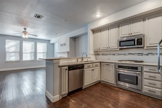 a kitchen with stainless steel appliances granite countertop a stove a sink and a microwave
