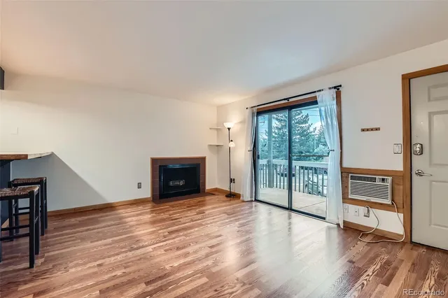 a view of empty room with wooden floor and fireplace