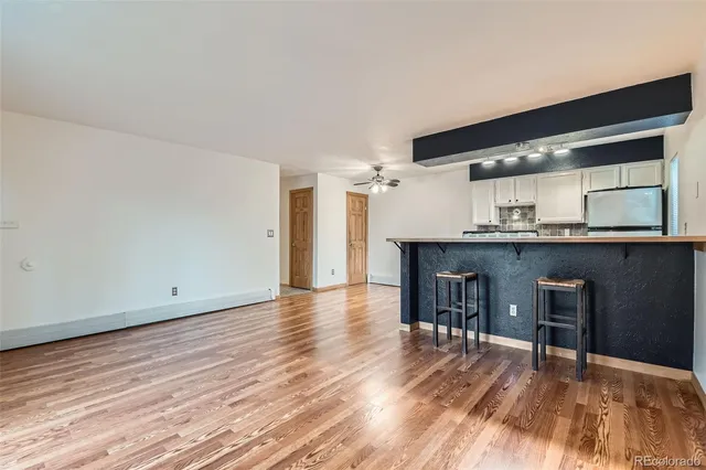 a view of a room with wooden floor and a ceiling fan