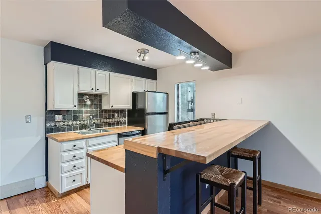 a kitchen with stainless steel appliances granite countertop a stove refrigerator sink and cabinets