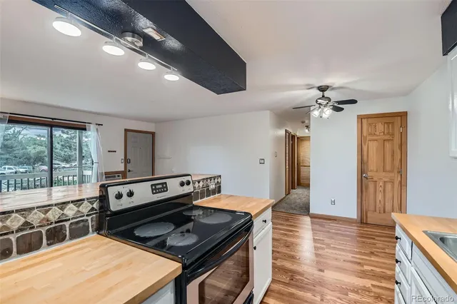 a kitchen with a stove and a wooden floor