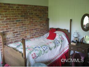 390 Sourwood Ridge Road Tryon, NC 28782 - Photo 5 of 6 a bed sitting in a bedroom next to a wall
