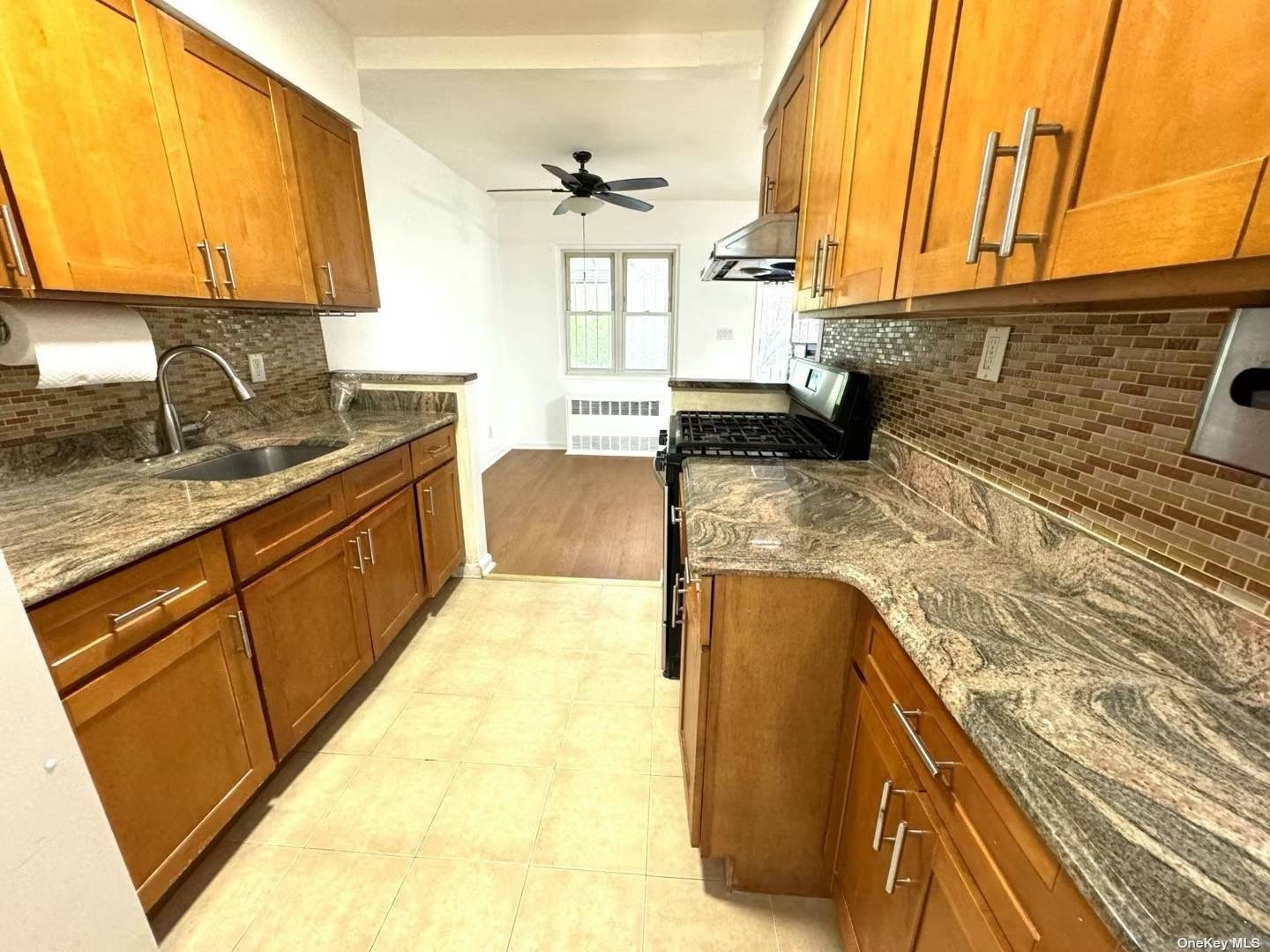 a kitchen with a sink a counter top space cabinets and stainless steel appliances