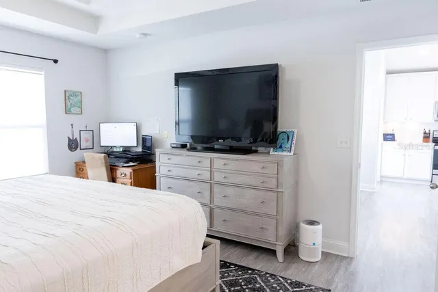 a large bedroom with a bed and flat screen tv