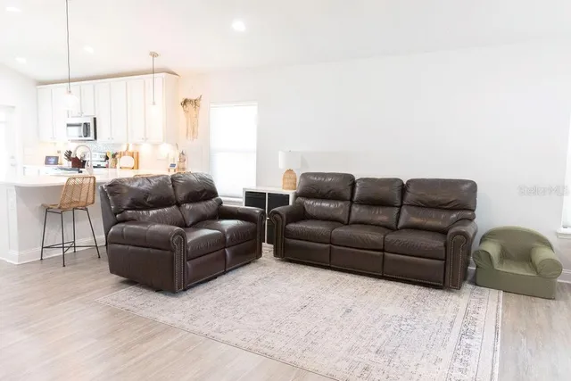 a living room with furniture a couch and kitchen view