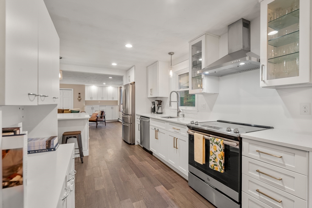 62 Gregory Road Framingham, MA 01701 - Photo 12 of 42 a kitchen with stainless steel appliances granite countertop a stove a sink dishwasher and a refrigerator with wooden floor
