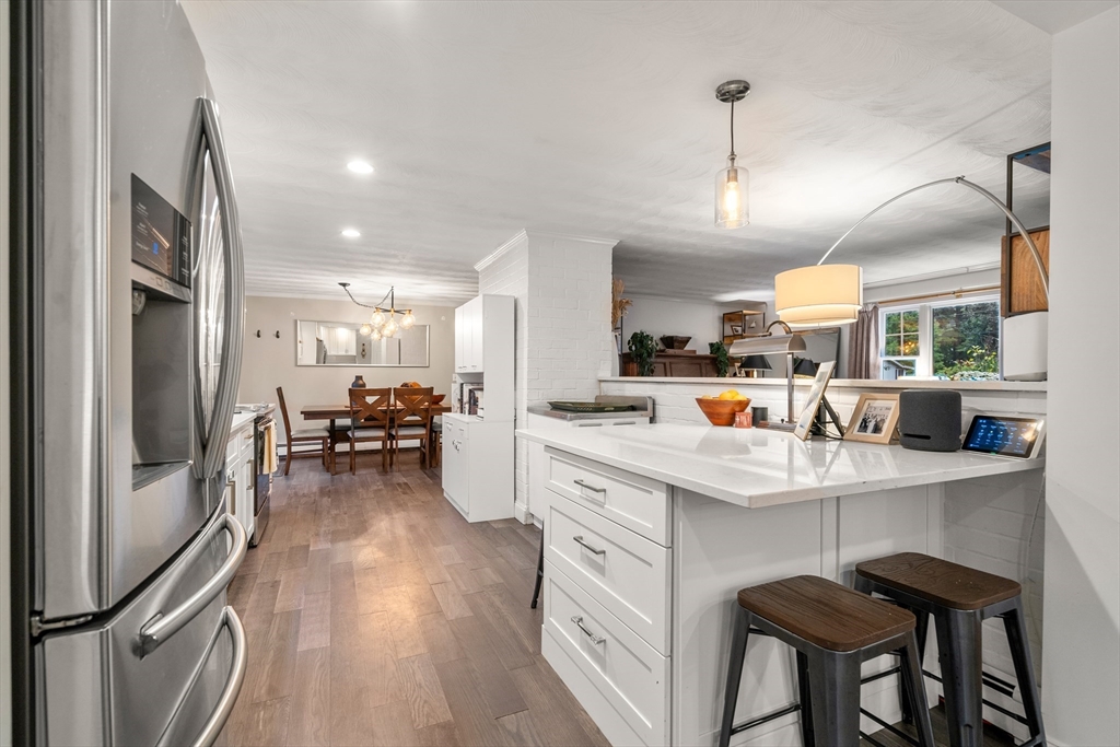 62 Gregory Road Framingham, MA 01701 - Photo 13 of 42 a kitchen with stainless steel appliances a dining table chairs stove and refrigerator