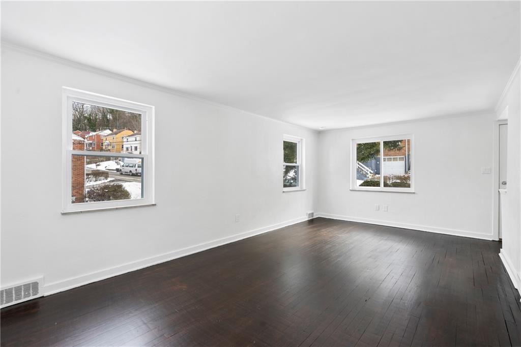 2041 Lindsay Road Pittsburgh, PA 15221 - Photo 5 of 24 a view of an empty room with wooden floor and a window