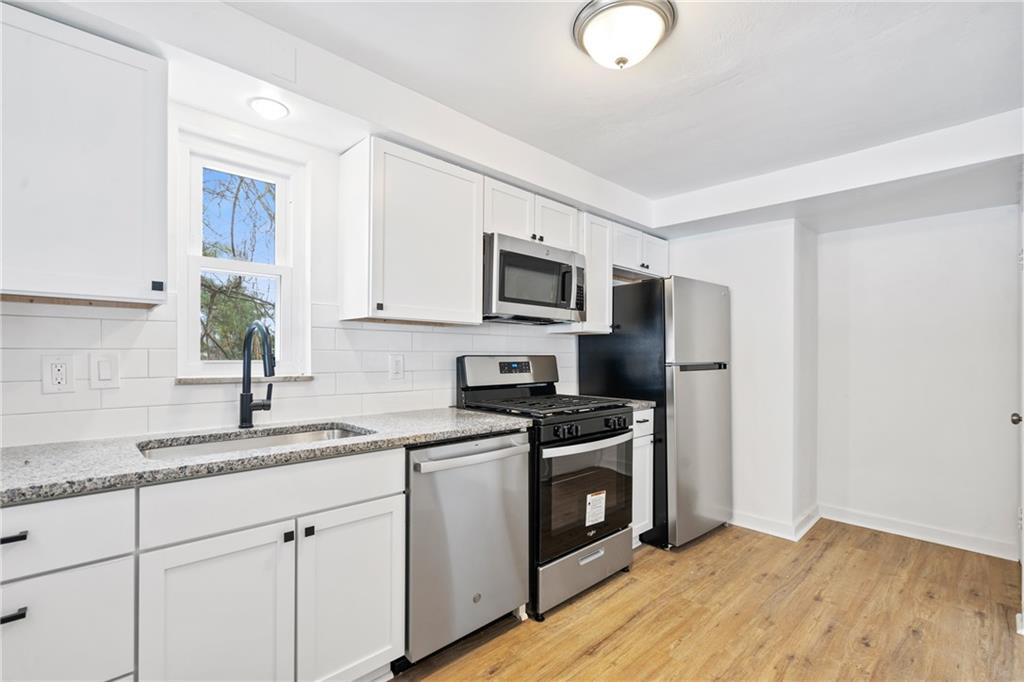 2041 Lindsay Road Pittsburgh, PA 15221 - Photo 10 of 24 a kitchen with stainless steel appliances granite countertop a sink a stove a refrigerator with grey cabinets