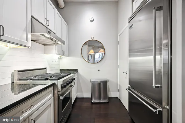 a kitchen with stainless steel appliances granite countertop a stove and a refrigerator