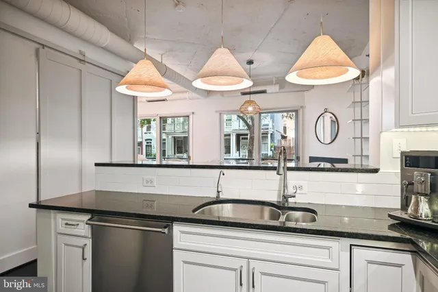 a kitchen with stainless steel appliances granite countertop a sink and a white cabinets