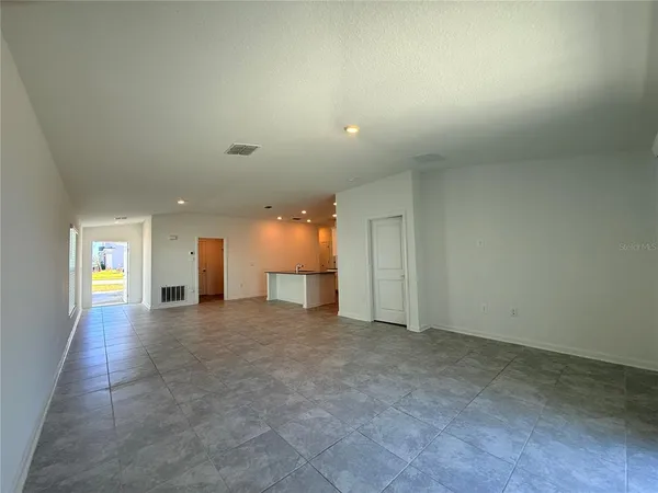 an empty room with windows and fireplace