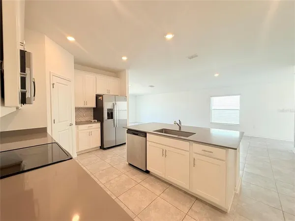 a kitchen with granite countertop a sink and white stainless steel appliances