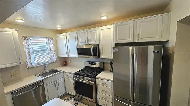 a kitchen with stainless steel appliances granite countertop a refrigerator stove and sink