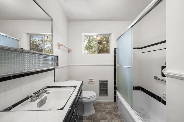 a bathroom with a toilet sink and mirror