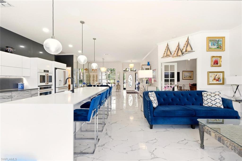 209 Countryside Drive Naples, FL 34104 - Photo 18 of 50 Living room featuring light marble finish floors and crown molding
