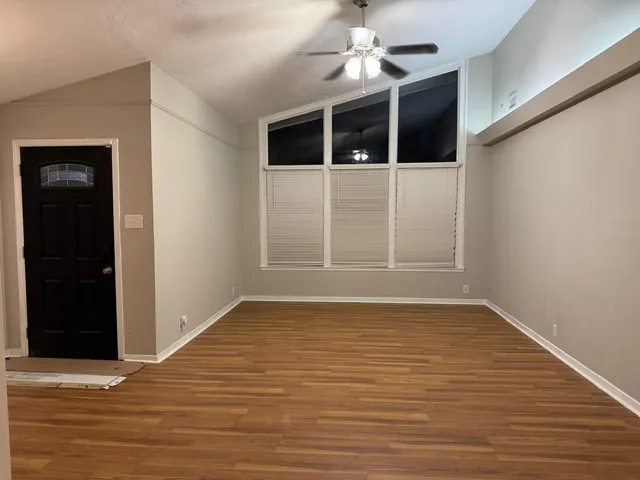 a view of a room with wooden floor closet and a ceiling fan