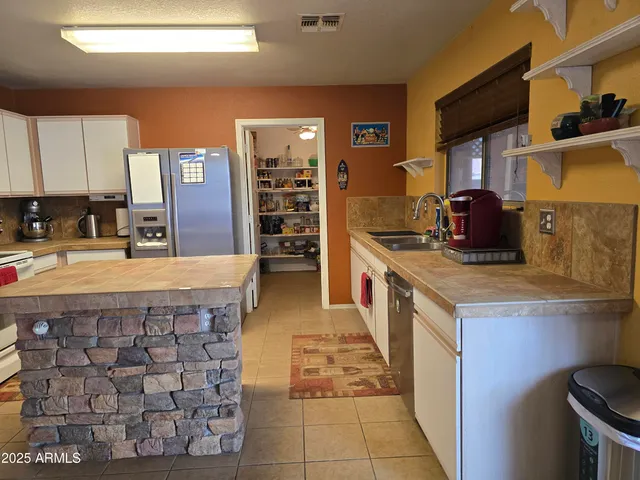 a kitchen with stainless steel appliances granite countertop a stove a sink and a refrigerator