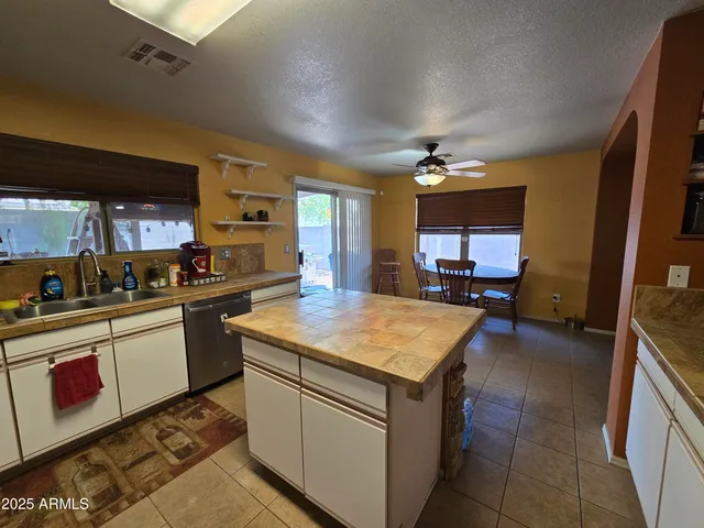 a kitchen with kitchen island granite countertop a sink counter top space appliances and cabinets