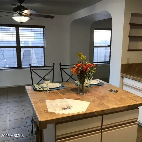 a dining room with kitchen island granite countertop wooden cabinets and a granite counter top