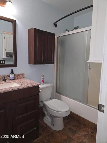 a bathroom with a granite countertop sink toilet and shower