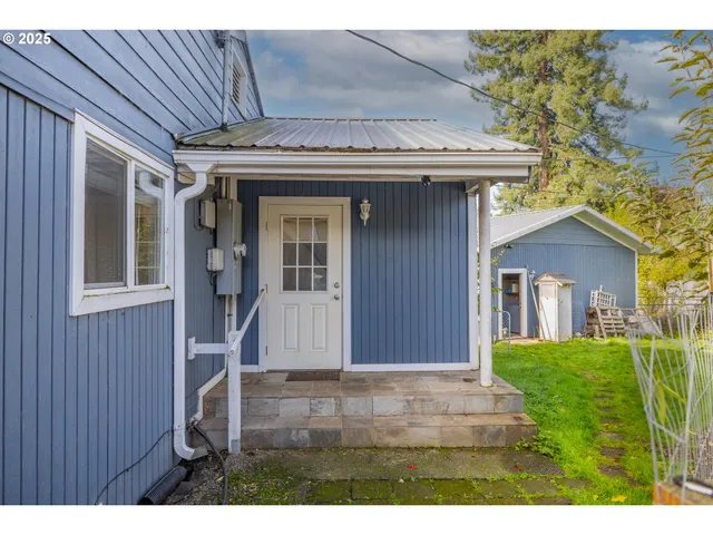 a view of a house with a small yard and wooden fence
