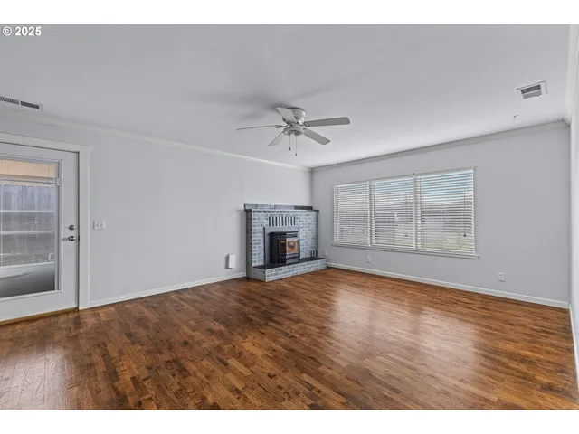a view of an empty room with a fireplace and a window