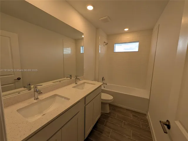 a bathroom with a sink double vanity granite tub and a mirror