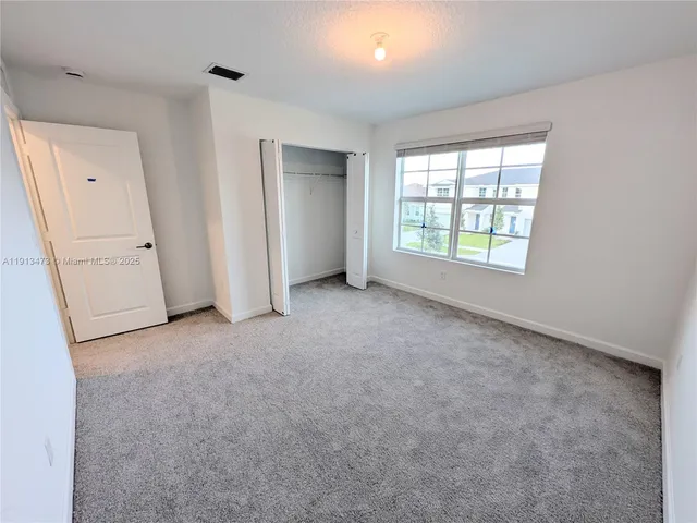 an empty room with windows and closet