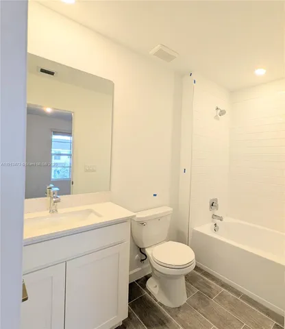 a bathroom with a toilet a sink a mirror and vanity