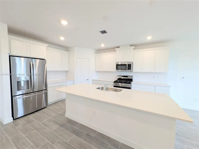 a kitchen with stainless steel appliances a refrigerator stove microwave and sink